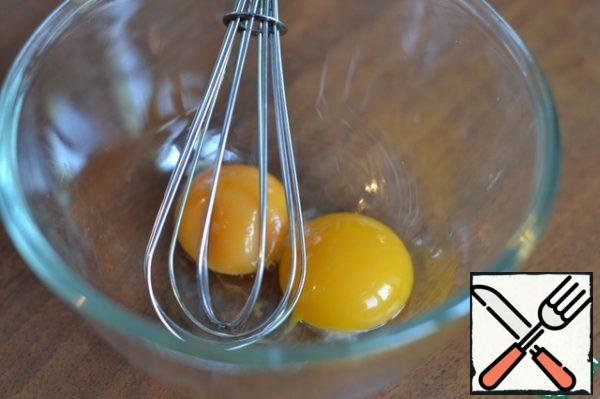 Separately, whisk the yolks in a bowl, gradually add flour to make a semi-liquid dough.
The dough should drain from the spoon.