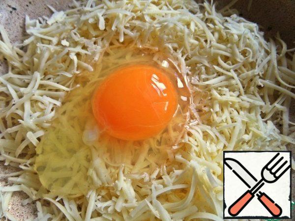 Grate the cheese, beat the egg.