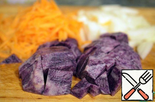 Peel the carrots and grate on a coarse grater, peel the onion and cut into small pieces, peel the potatoes and cut into cubes.