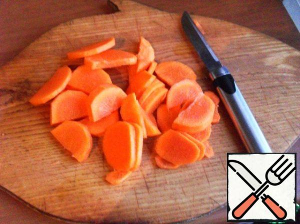 While the chicken backs are baking, peel the carrots and cut into slices. Or semi-rings, if the carrots are large.