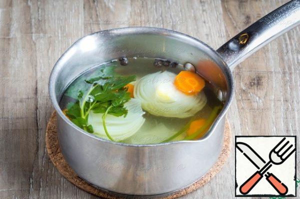 The first thing you need to put the broth to cook. Peel the onion and cut it in half, cut the celery into two halves, carrots in thick slices, greens. Pour water into a saucepan, put the prepared vegetables and put them on a large fire. When the water boils, add salt and pepper, reduce the heat to a light boil and leave the broth to boil for about 30 minutes.