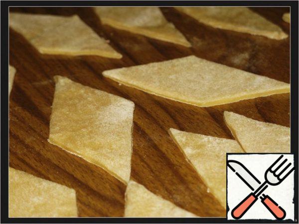 From flour, eggs, salt, cheese, knead the dough like dumplings.
Let the dough stand for 15-20 minutes. On the flour table, roll out the dough 2 mm thick, cut it into squares or lozenges, leave to dry for 20-30 minutes.