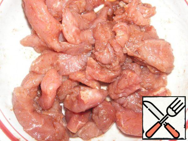 Cut the meat into small pieces, sprinkle with spices, as well as soy sauce and crushed garlic.