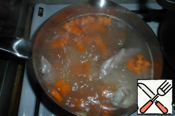 Strain the broth, add salt and seasoning, chopped carrots and onions. Cook for another 15 minutes.