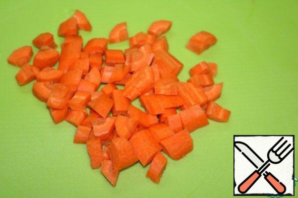 Put a saucepan with 1.5 liters of water on the stove. Carrots, cut into large cubes, put in a baking pan.
