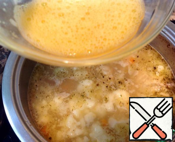 As soon as the soup boils, shake 1 egg and a thin stream, stirring, pour into the soup.
