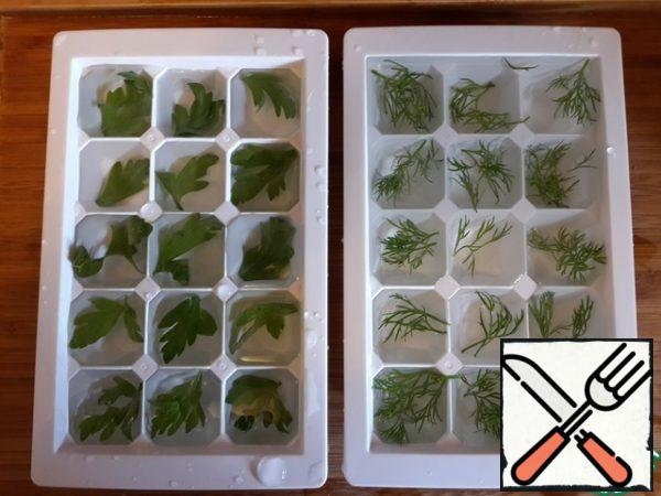 Put a leaf of parsley or dill in each cell, fill with water and freeze.
These beautiful ice cubes can be used to cool the okroshka - just put a few cubes in a plate. It looks very impressive.