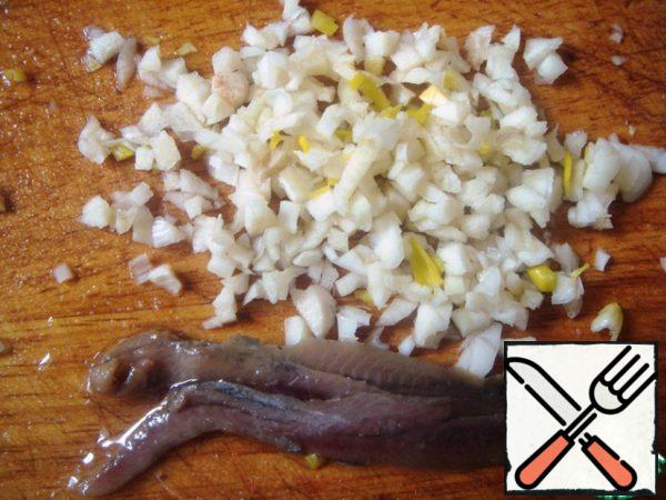 Clean 2 cloves of garlic, finely chop,same act with anchovies - if you decide to add.