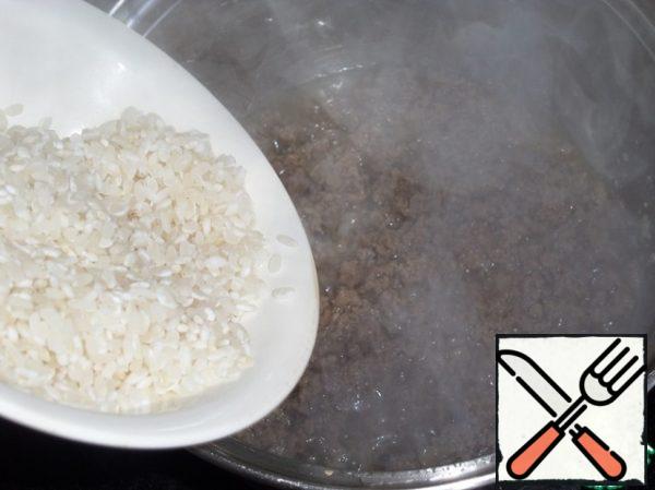 Then add the washed rice to the minced meat in the pan.
