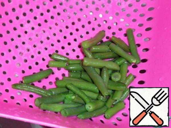 Then we throw the beans into a colander and pour cold water.
