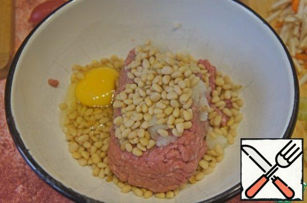 Minced meat miss through a meat-grinder together with sausage, onions, nuts.
Beat the egg, salt, pepper and knead.