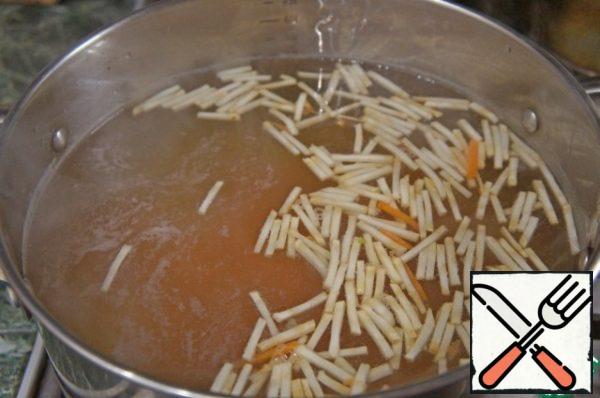 In the boiling broth to put potatoes cut into cubes, bring to boil, add the carrots and celery, cut into strips or slices, again to finish to boiling.
Reduce the heat to low and put in soup meatballs. Cook over low heat for 10 minutes.