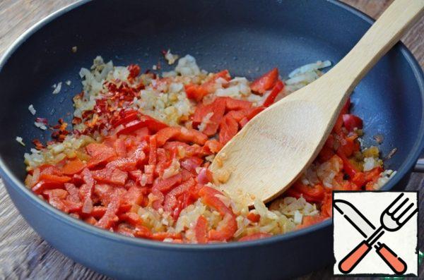 In a deep frying pan fry the finely chopped onion and garlic, add shredded sweet pepper and chili pepper, fry for 5 minutes.