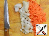 Onion cut into cubes, carrots grate on a grater.