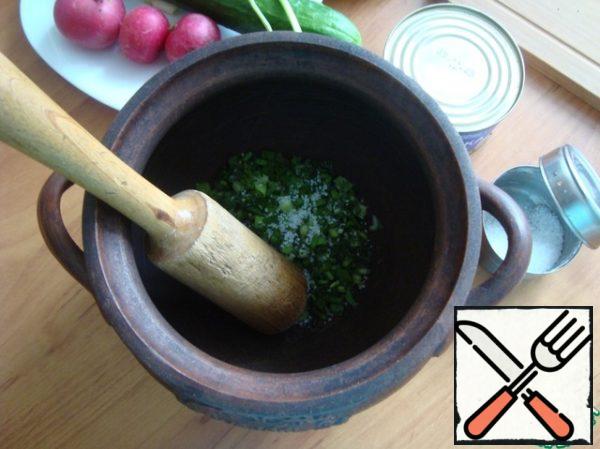 For okroshka, I always take a large clay pot.
Finely chop the onion and dill. We send it to the pot, sprinkle with salt and cool it.
Chop the onion with dill malkai until it releases the juice. I have a wooden pusher for this purpose. I always cut the vegetables into very small cubes, chop the parsley finely and put it in a saucepan.