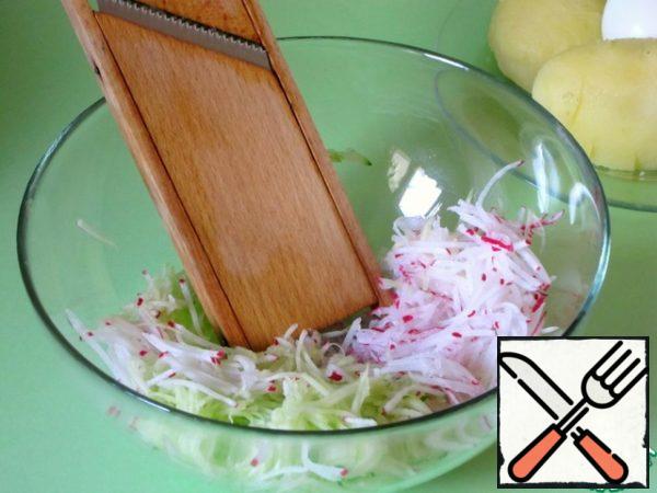 Peeled boiled potatoes, cucumbers, radishes, eggs grate on a carrot grater in Korean. Vegetables are obtained in the form of long thin straws.
