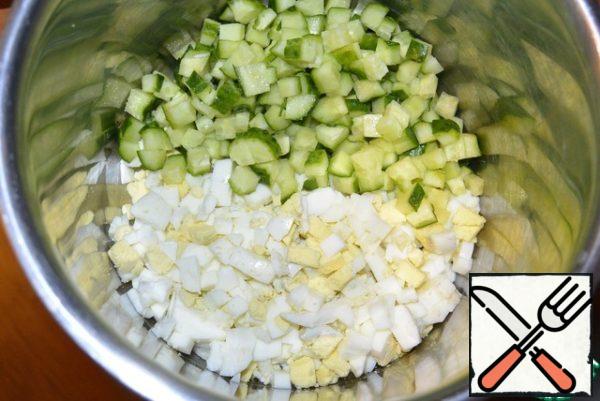 Cut into cubes cucumbers, boiled eggs and