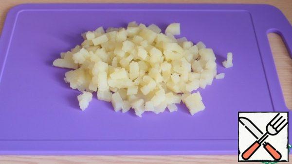 Boil potatoes in a uniform, cut into cubes.