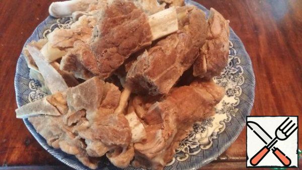 Boil the beans with pearl barley, pork and beef ribs. Separate the meat from the bones and cut into small pieces. Go back to the soup.
