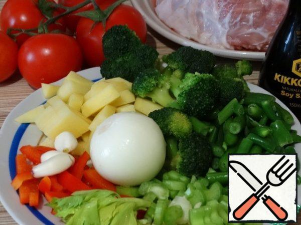 While the broth is cooked, prepare vegetables. Potatoes cut into slices, about the same size as the pieces of string beans. The same pieces cut and red bell peppers. Broccoli disassemble on inflorescences. Cut the onion into cubes, finely chop the garlic. Tomatoes-cubes.
