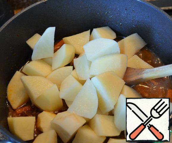 Peel potatoes and cut into pieces according to the size of meat.
Put in the cauldron.
Simmer over medium heat.