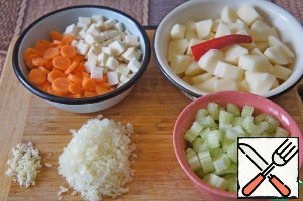 Wash the celery and cut the stalks into 0.5-1 cm. Wash the carrots, peel and cut into slices 0.5–1 cm thick. Peeled potatoes cut into 2 cm cubes . Remove the top and bottom of the chili pepper. Finely chop the coriander. Chop the spinach.
