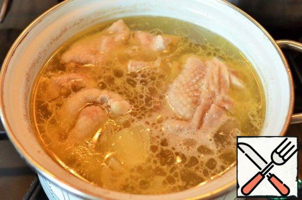 Prepare the broth. Boil chicken pieces with onions and carrots in 1.5 liters of water for 15-20 minutes. Use a bone from the breast.
