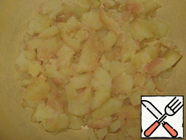 Boil the potatoes in their skins. Clean and cut.