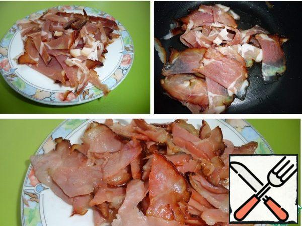In a saucepan with a thick bottom, heat the vegetable oil over medium heat and fry the bacon until golden brown. Transfer to a plate.
