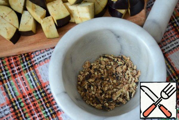Eggplant cut into cubes, add to the cauldron, fry for 3 minutes.
Dried eggplant, mushrooms and seeds crushed in a mortar.