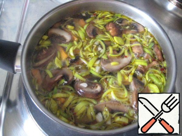 Add the hot broth, mushrooms and cook for 10-15 minutes, add the leeks, chopped in thick rings and cook for another 5 min.