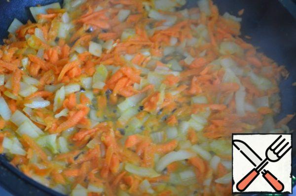 Clean, wash carrots and onions. Onion cut into cubes. Carrots grate on a coarse grater. Preheat the pan, pour 3 - 4 tablespoons of vegetable oil. Fry, stirring, over medium heat for 3-4 minutes. Add to vegetables flour flavored. Mix quickly.