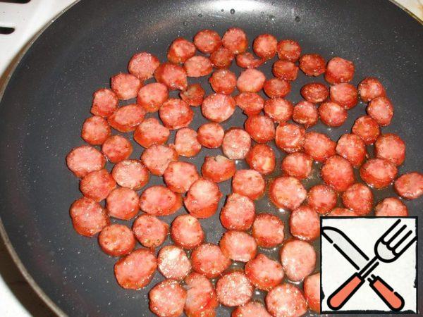 Fry the smoked sausages or bacon slices.
