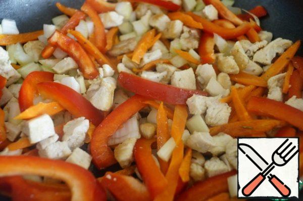 Heat the vegetable oil in a frying pan and put carrots and chicken on it. Lightly fry and add the bell pepper and celery. Cook for about 5 minutes.