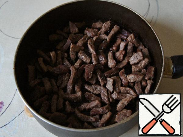 Heat the oil and fry the meat until golden brown.
