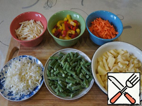 Meanwhile, prepare the vegetables. Wash, peel and cut carrots and celery sticks, potato cubes, leek - polyolefine, pepper - wide strips.