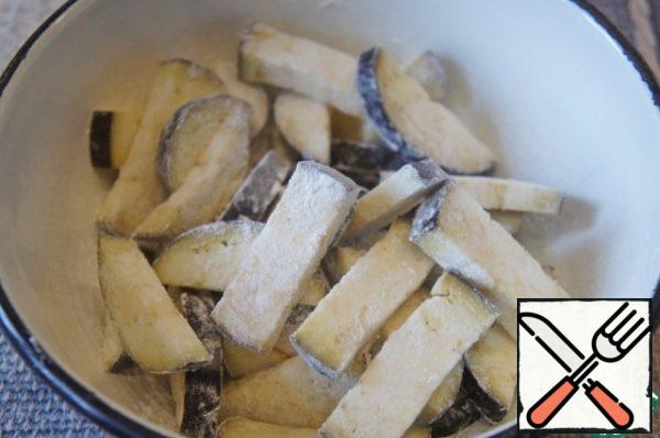 Cut eggplant into slices, roll in flour.
