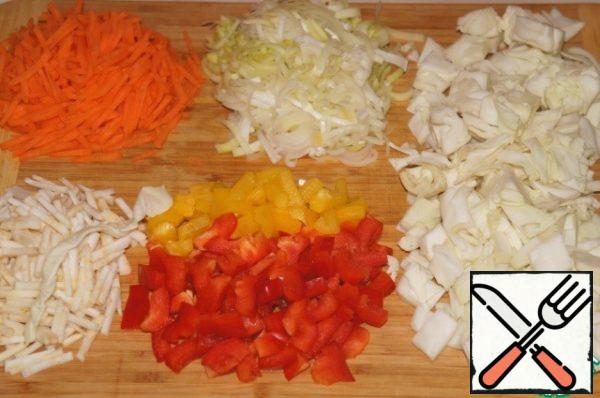 Cabbage cut into small cubes, carrot and celery and chop sticks, peppers cut into pieces. Leek cut into half circles and very carefully rinse in a colander under running water.