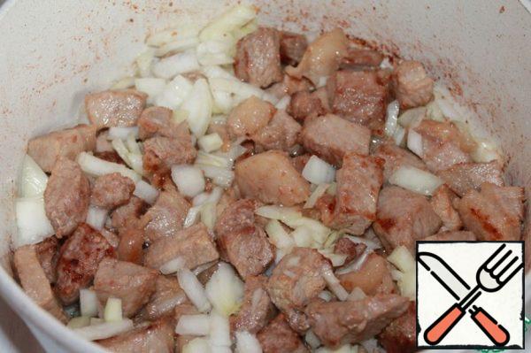 To the meat add chopped onion and continue to fry.
