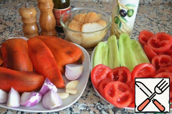 Cut the tomatoes in half, remove the seeds from the halves and discard them in a colander set over the pan to collect the juice. Spoon the seeds into a colander to squeeze out more juice.
Peel the cucumber and remove the seeds with a teaspoon.
Using a vegetable peeler, peel the peppers, remove the seeds and the shell.
Peel the onions and garlic.