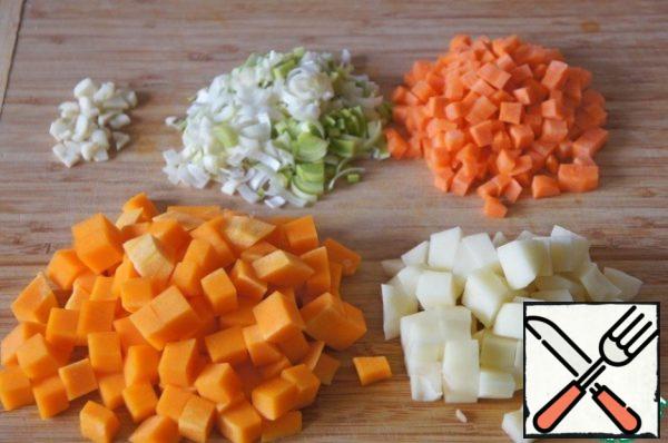 Carrots cut into small cubes, pumpkin and potatoes larger cubes, onion - thin half-rings and the garlic and ginger slice.