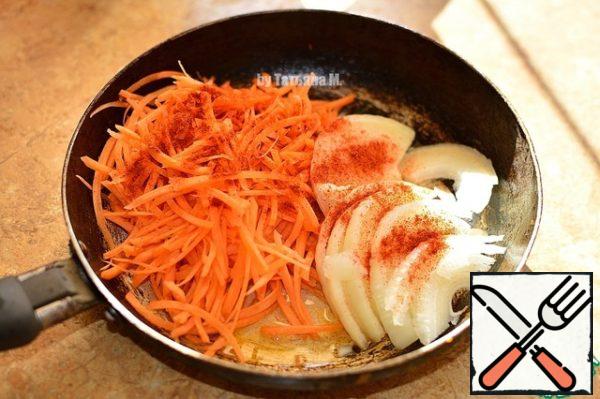 Onions and carrots cut into thin strips, fry in a pan with oil, adding paprika.