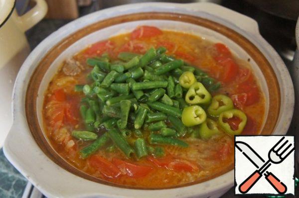 Open the lid and add finely chopped green beans and chopped hot pepper to the soup.