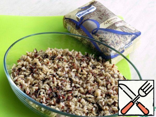 The rice is boiled, as it is written on the package, in salted water and spread in a baking dish greased with vegetable oil.

