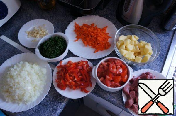 Prepare all the ingredients:
Wash the meat cut into squares and Pat dry with paper towel.
Onions cut into cubes.
Carrots cut into thick strips.
Tomato cut into small pieces.
Bell peppers cut in half rings.
Garlic cut into small pieces.
Cut potatoes into small cubes,greens chop and mix together.