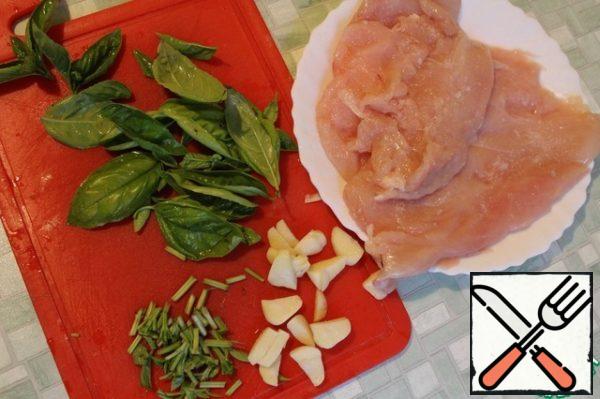 Chicken Breasts, close the two layers of film and otobem to a thickness of not more than 1 cm, with sprigs of Basil tear off the leaves, chop the branches themselves, garlic large cut.