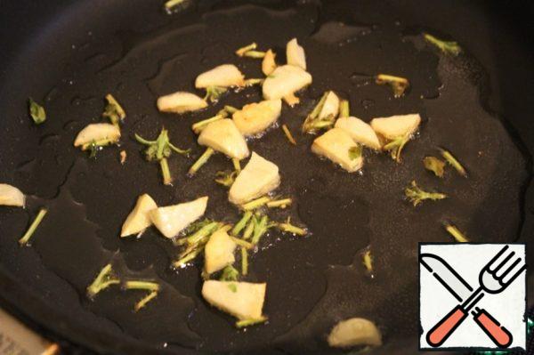 Heat a small amount of olive oil and fry the garlic and Basil branches until Golden.