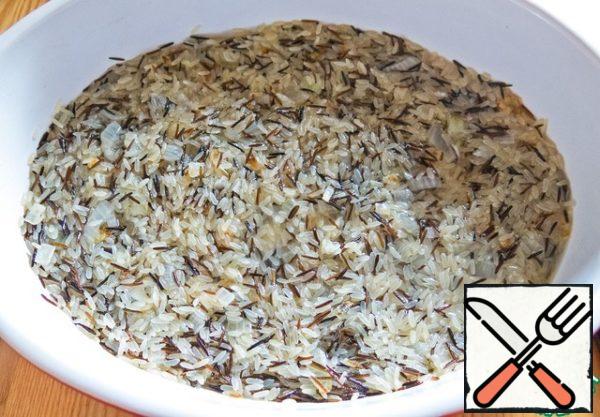Wash the rice. I have a mixture of steamed and wild rice. Mix rice with fried onions, salt, pepper and spread in a greased vegetable oil form or in a deep pan. Pour water so that it does not cover the rice, and just seemed out of it.