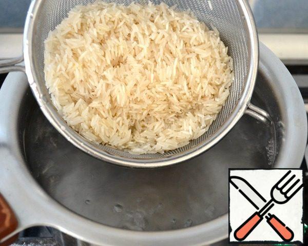 Rice put in a bowl and rinse several times with cold water. Then put in a colander and rinse again under running water. Put the rice in a pan with boiling salted water. Cook for 10 minutes.
