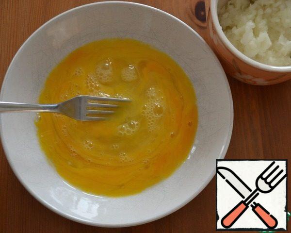 Break in a bowl of three eggs and stir with a fork. Add half of the chopped onion to the eggs.